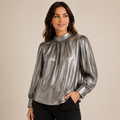 Woman wearing a silver metallic blouse against a beige background